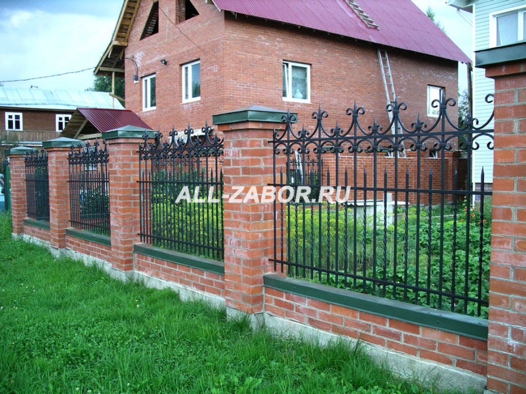 Кованый забор черного цвета с фундаментом и кирпичными столбами